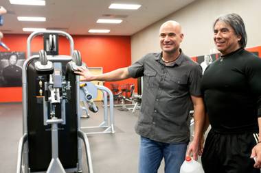 Tennis champion Andre Agassi and trainer Gil Reyes pose together for a Twitter photo after demonstrating their award-winning BILT C.O.D. fitness machine, designed by Agassi and Reyes, in the gym of the BILT Headquarters in Las Vegas Friday, April 26, 2013.